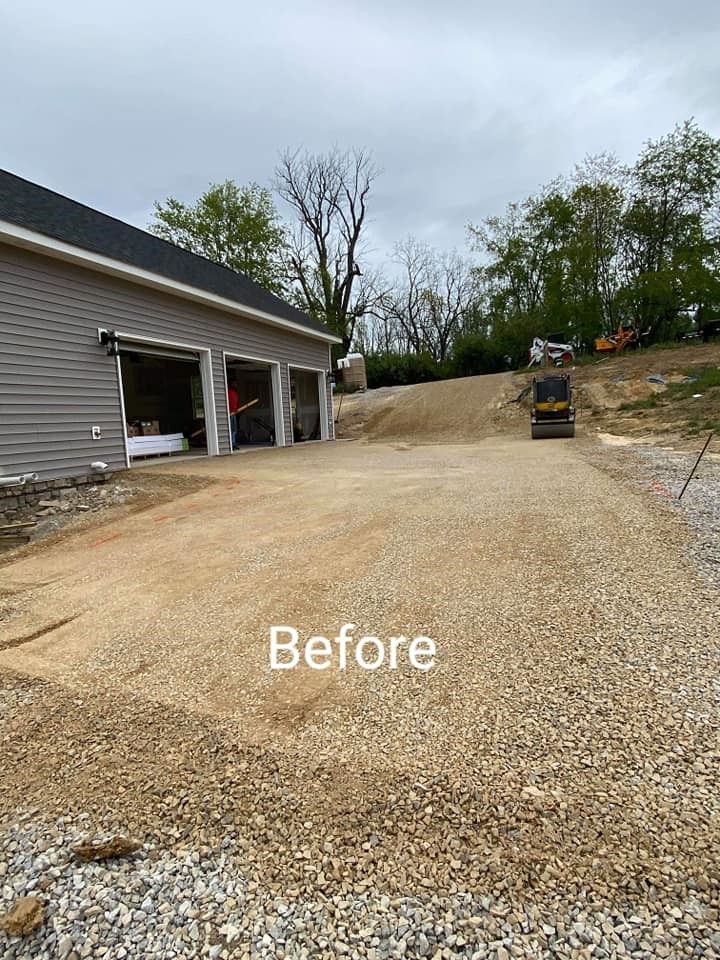 A before picture of a gravel driveway in front of a garage.