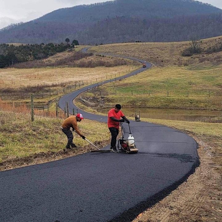 Two men are working on a road with mountains in the background