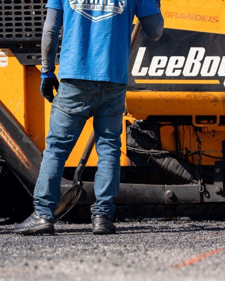 A man in a blue shirt is standing in front of a leebuck tractor
