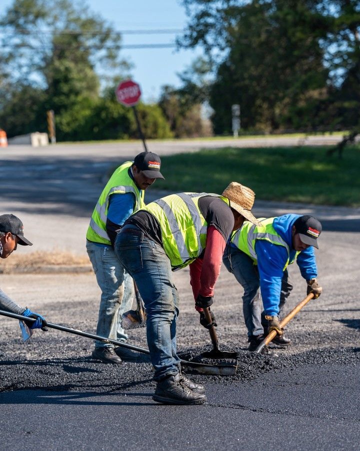 A group of construction workers are working on a road.