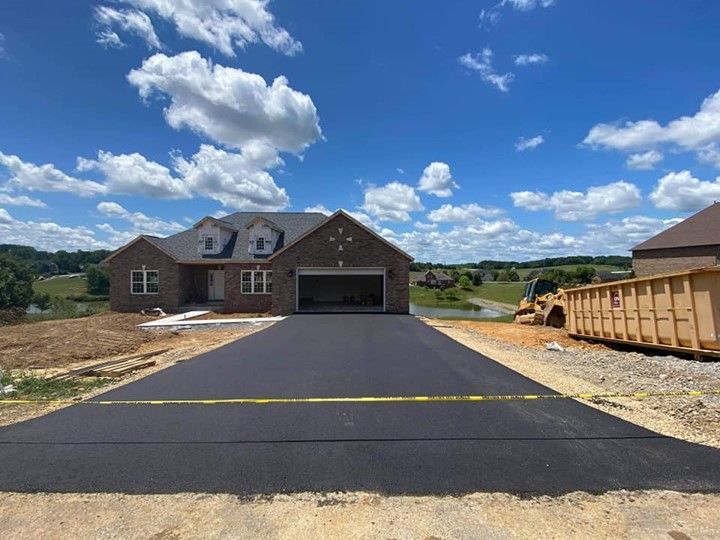 A large brick house with a large driveway in front of it.