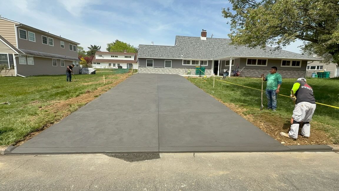 Newly poured concrete driveway with workers.