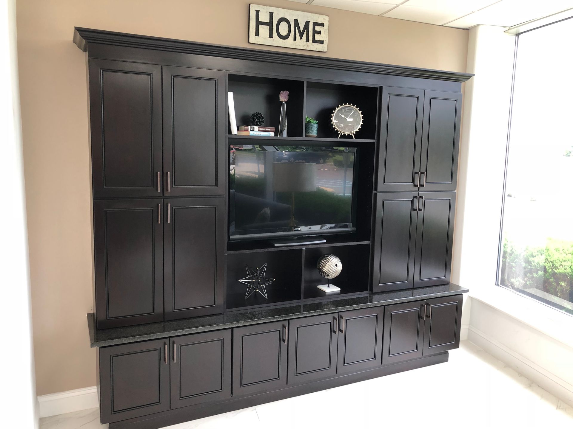 Dark brown built-in entertainment center with TV, storage cabinets, and a 