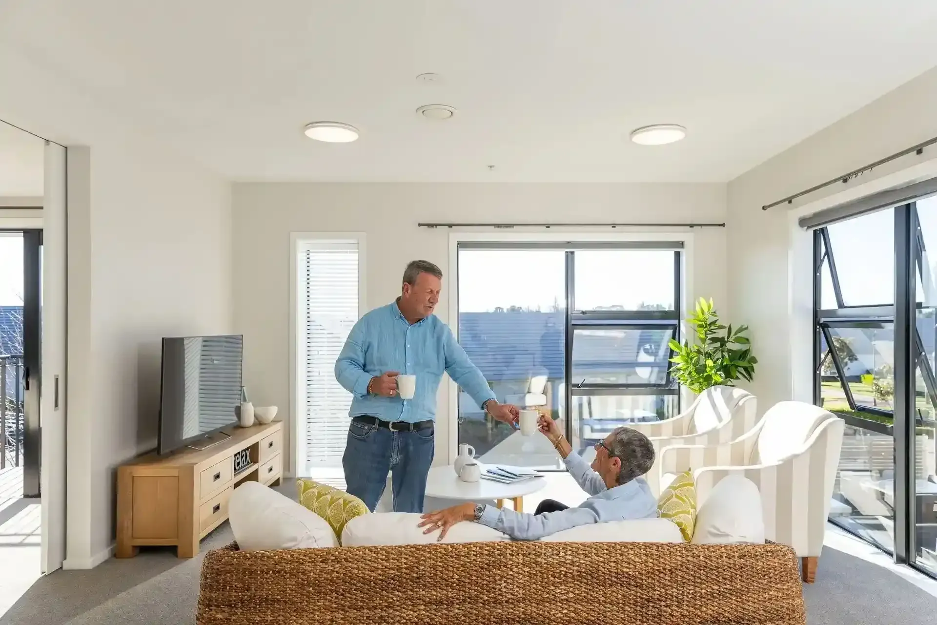 Residents sharing tea in sunlit living room