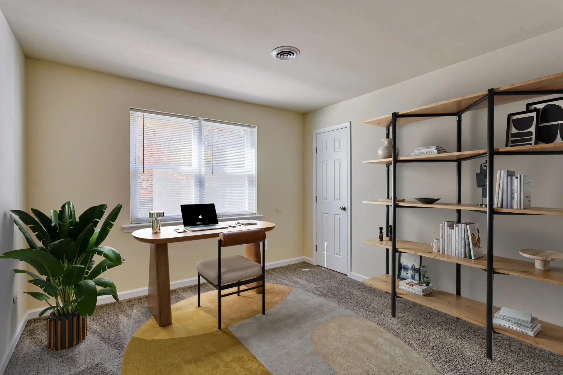 Brookbend Apartments Home office corner in a modern apartment with desk, chair, shelving, and plant.