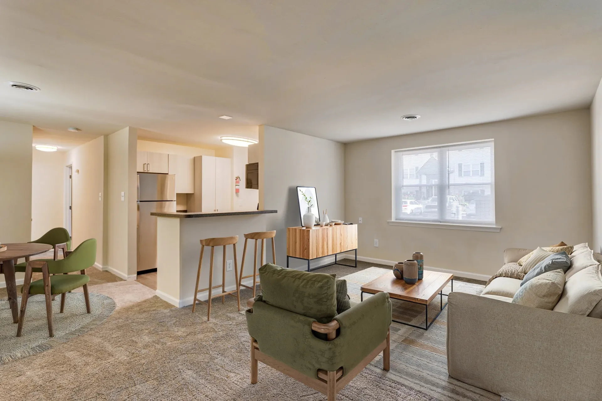 Brookbend Apartments Open-concept living area with kitchen bar, dining table, and large window.