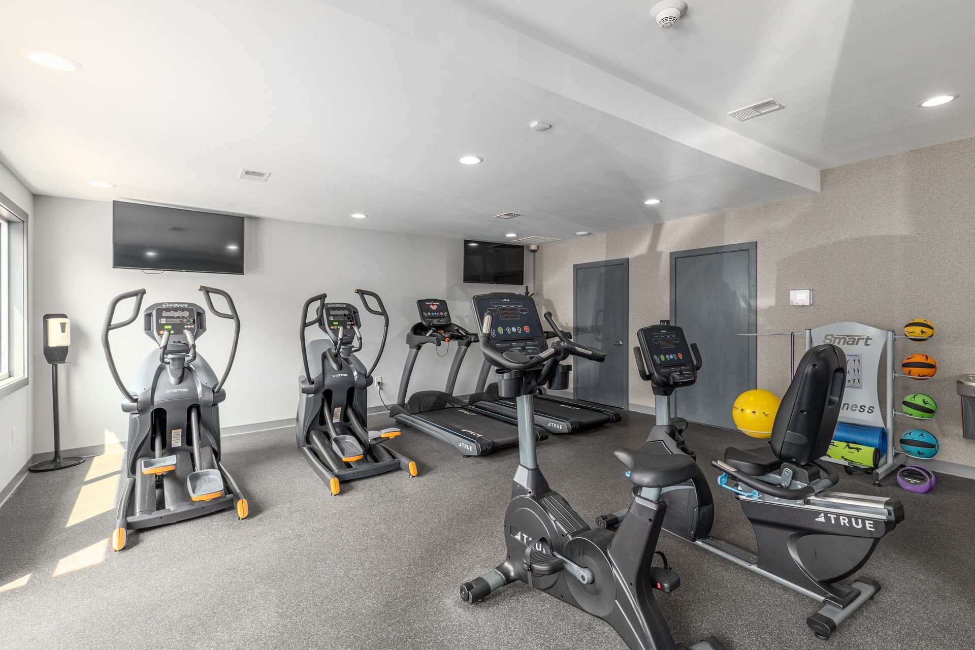 Brookbend Apartments Gym with various exercise machines, including ellipticals, treadmills, and stationary bikes.