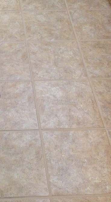 Accessible beige tiled shower with bench, grab bar, multiple shower heads and fixtures.