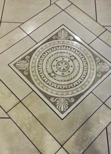 Accessible shower with built-in bench, grab bar, multiple shower heads, and tiled walls/floor.