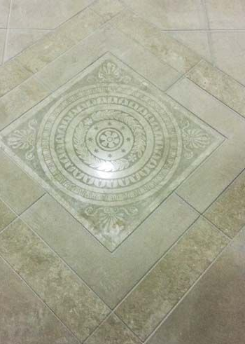 Accessible beige tiled shower with bench, grab bar, multiple shower heads and fixtures.