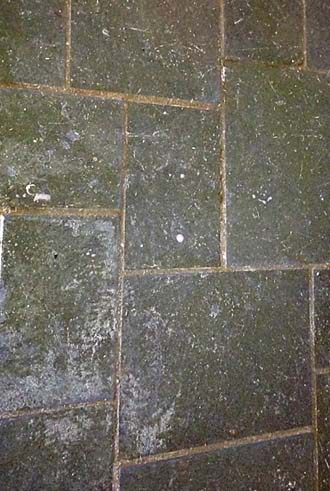 Accessible shower with built-in bench, grab bar, multiple shower heads, and tiled walls/floor.