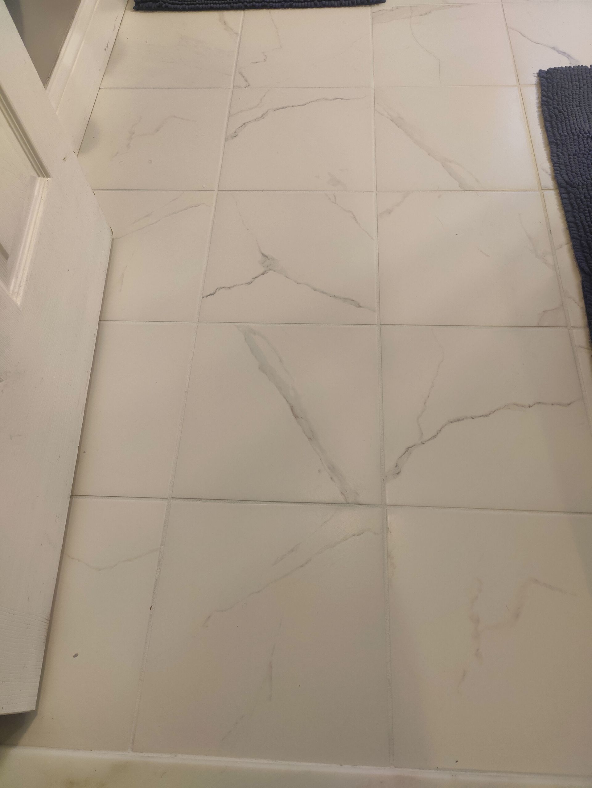 White marble-look tile floor with dark grout lines.