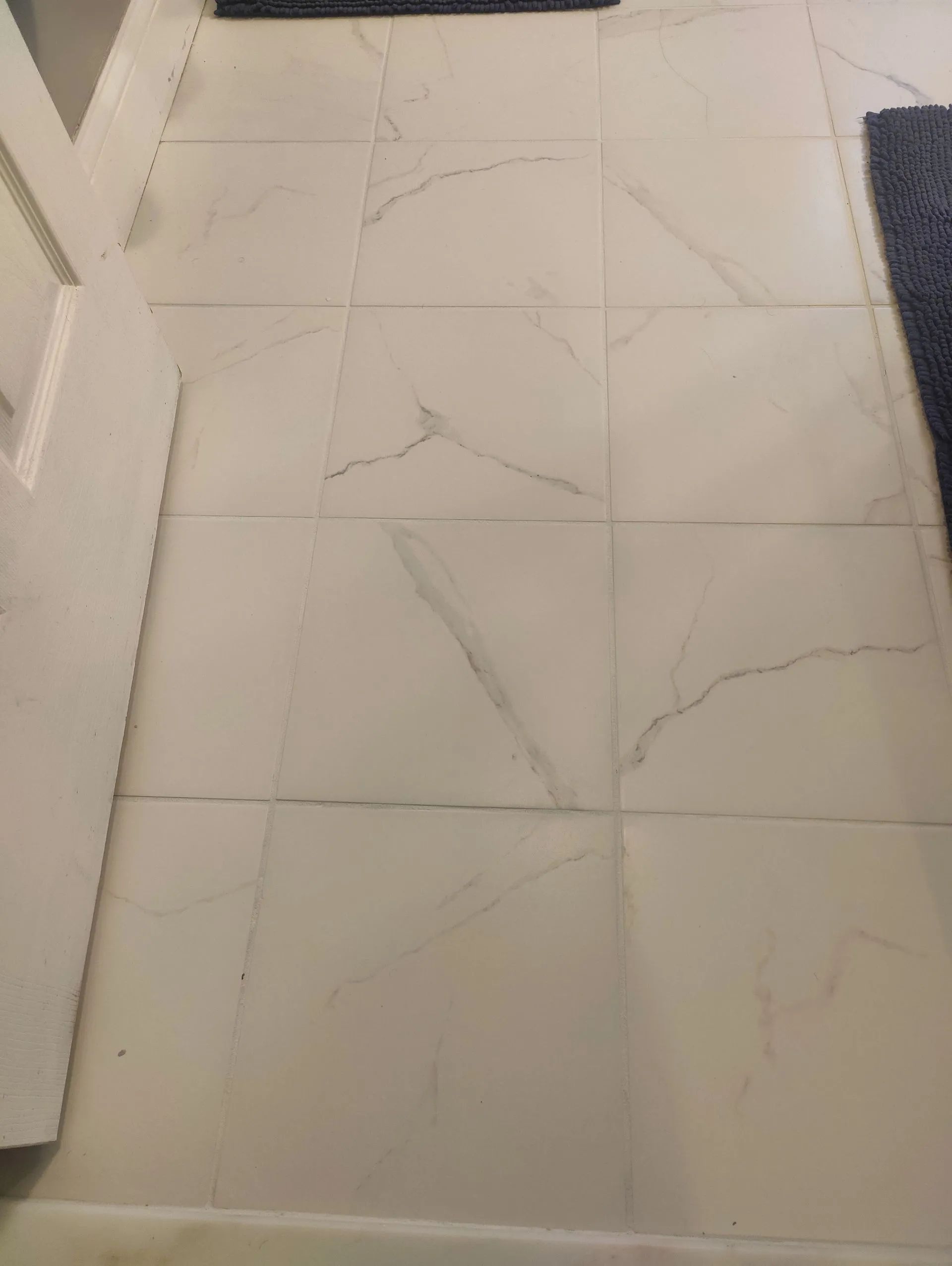 White tiled floor with marble-like veining.