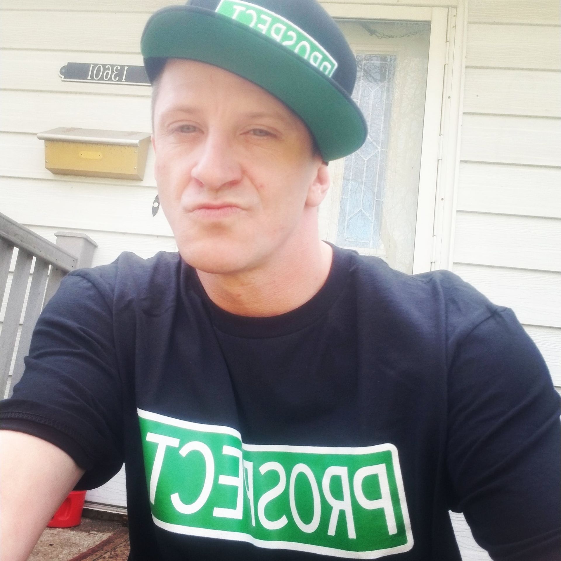 Man wearing black t-shirt and hat that says 