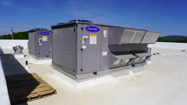 Commercial rooftop HVAC units on a flat white roof under a clear blue sky