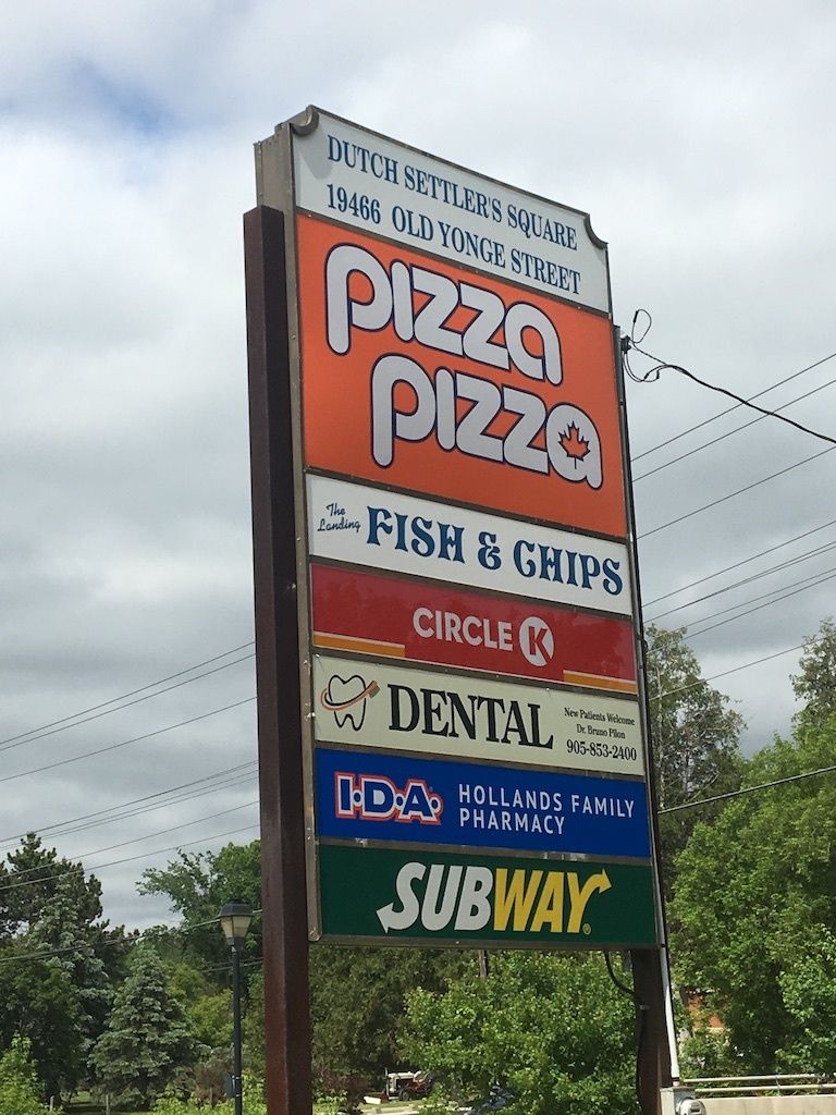 A sign for pizza pizza fish and chips and subway