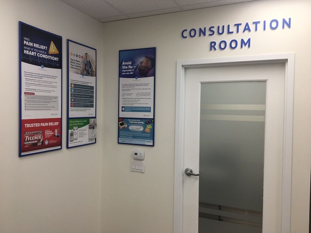 A consultation room with a glass door and posters on the wall