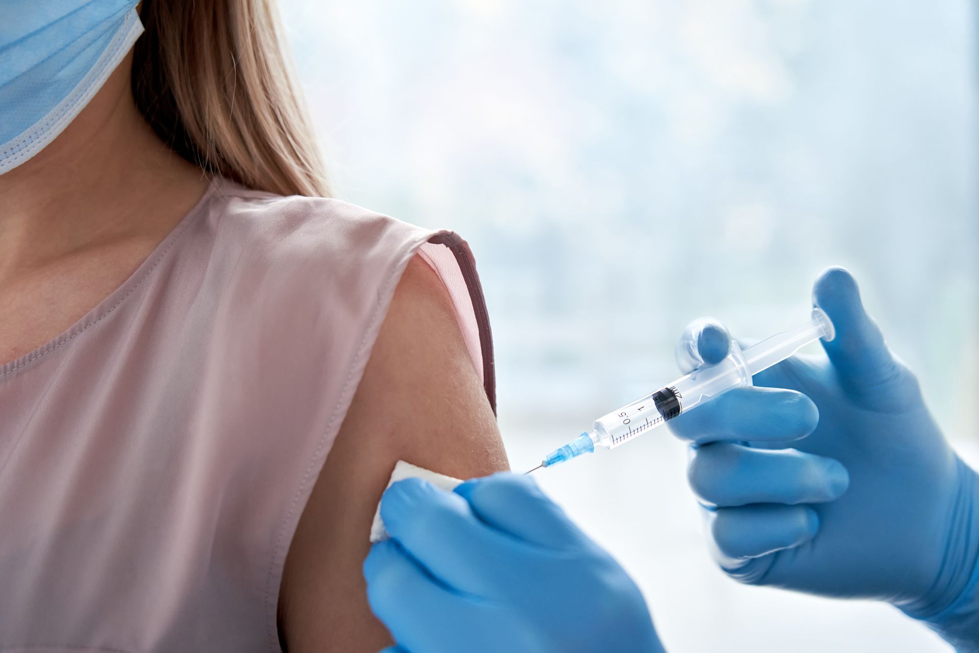 A woman is getting a vaccine in her arm.