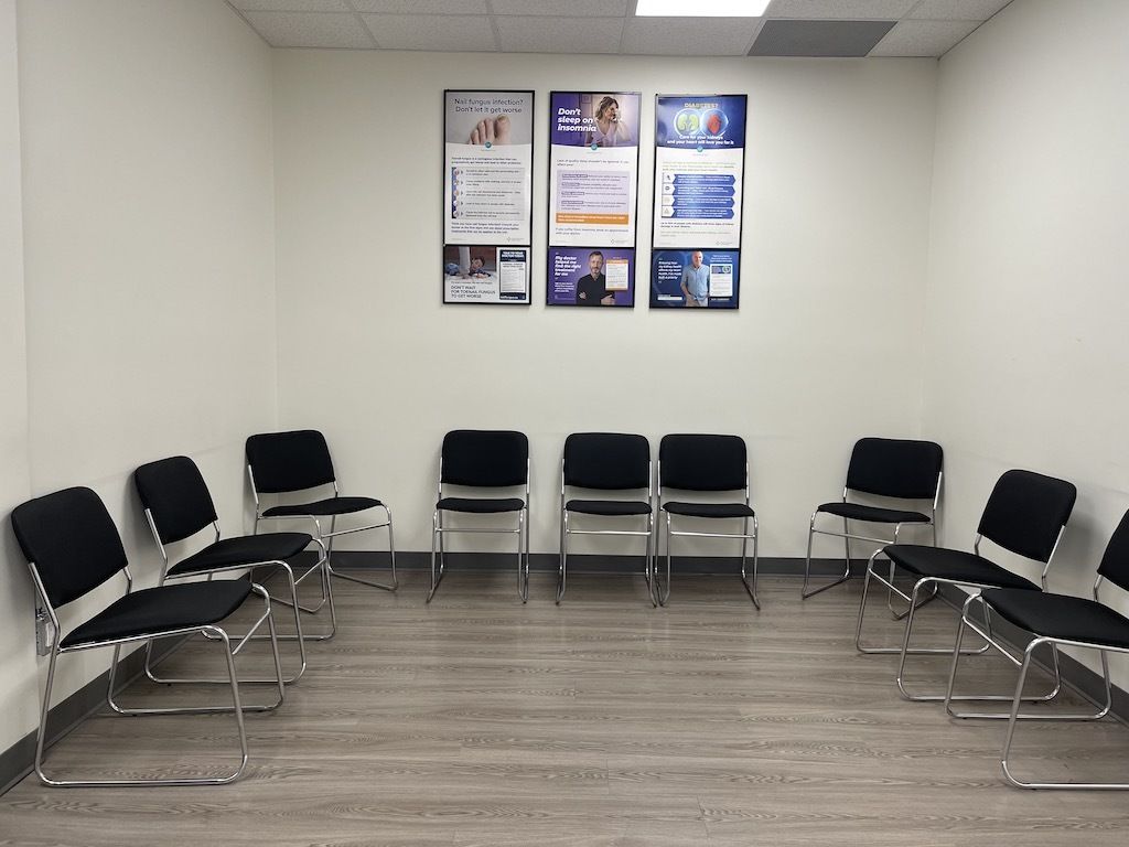 A waiting room with black chairs and posters on the wall
