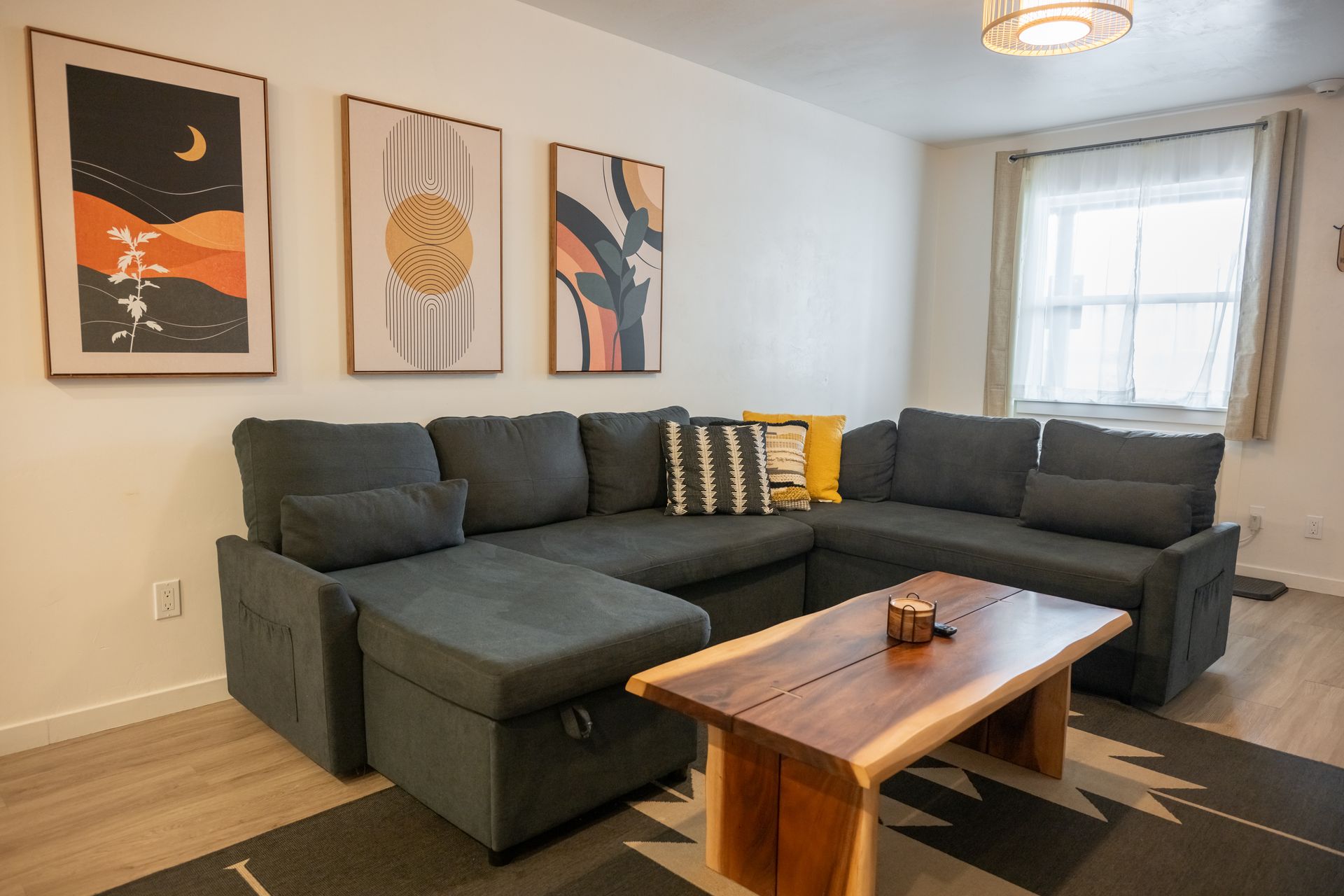 Cozy living room with a sectional sofa, coffee table, art, and rug.