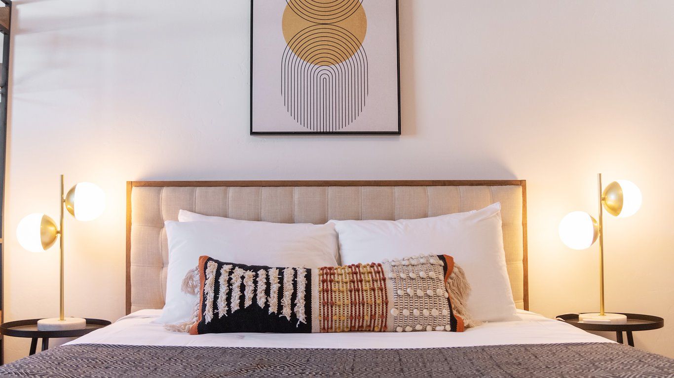 Bedroom with a bed, two nightstands, lamps, and a decorative pillow.