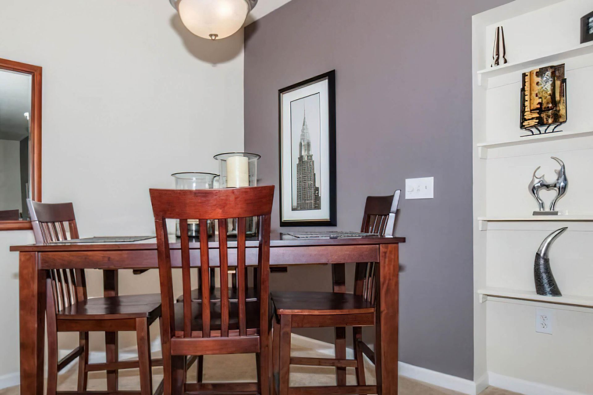 Echo Ridge apartment dining room with dining table, chairs, wall art, and designer lighting.