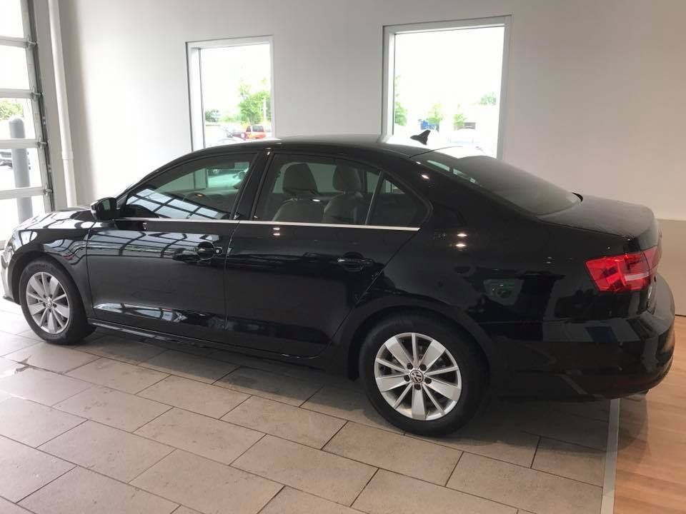 Black sedan parked inside a showroom with large windows.