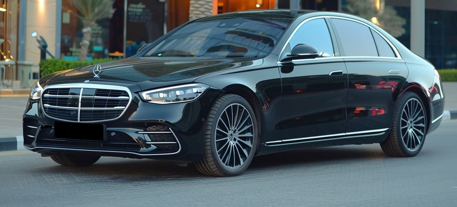 Black Mercedes sedan parked near a building with palm trees.