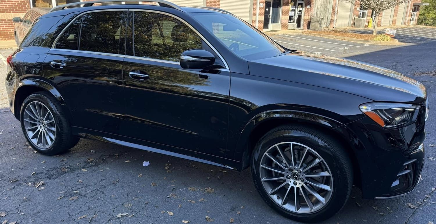 Black Mercedes-Benz GLE SUV parked on asphalt. Shiny black paint, tinted windows, and alloy wheels.