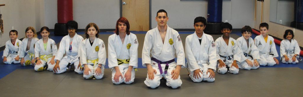 A group of karate students are posing for a picture