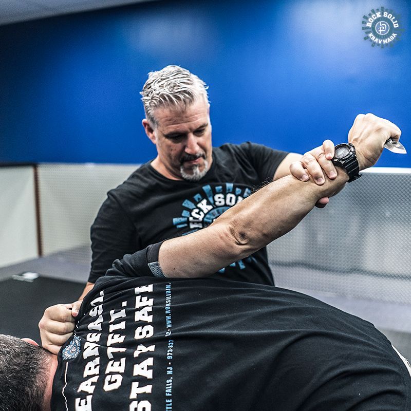 Two men are practicing martial arts in a gym.