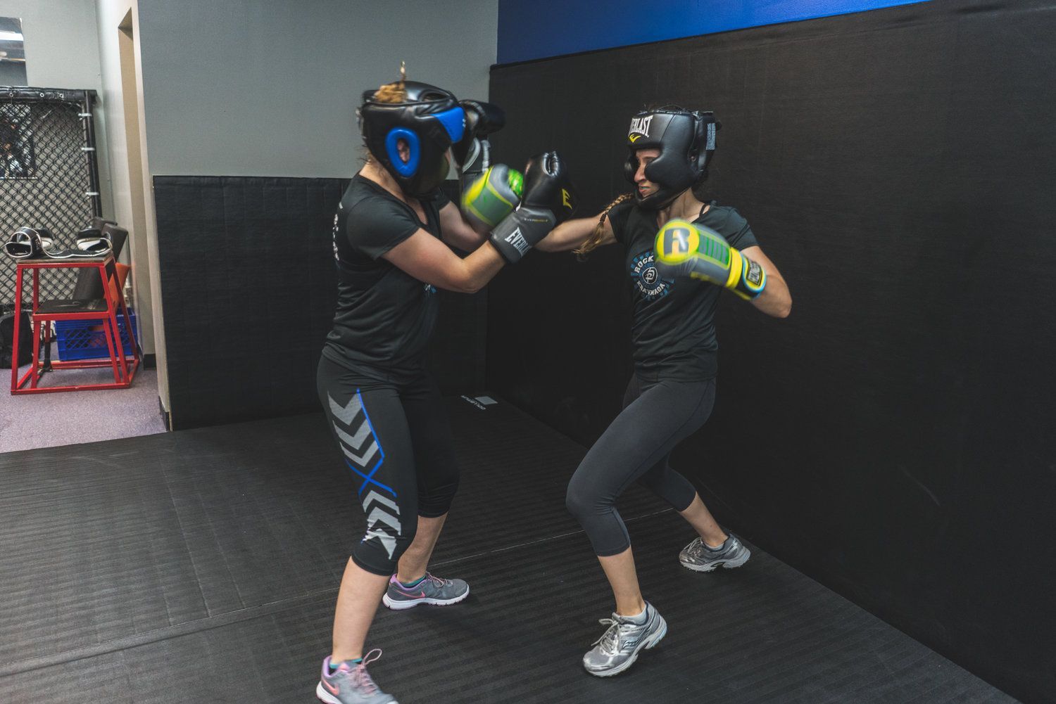 Two women are boxing in a gym.