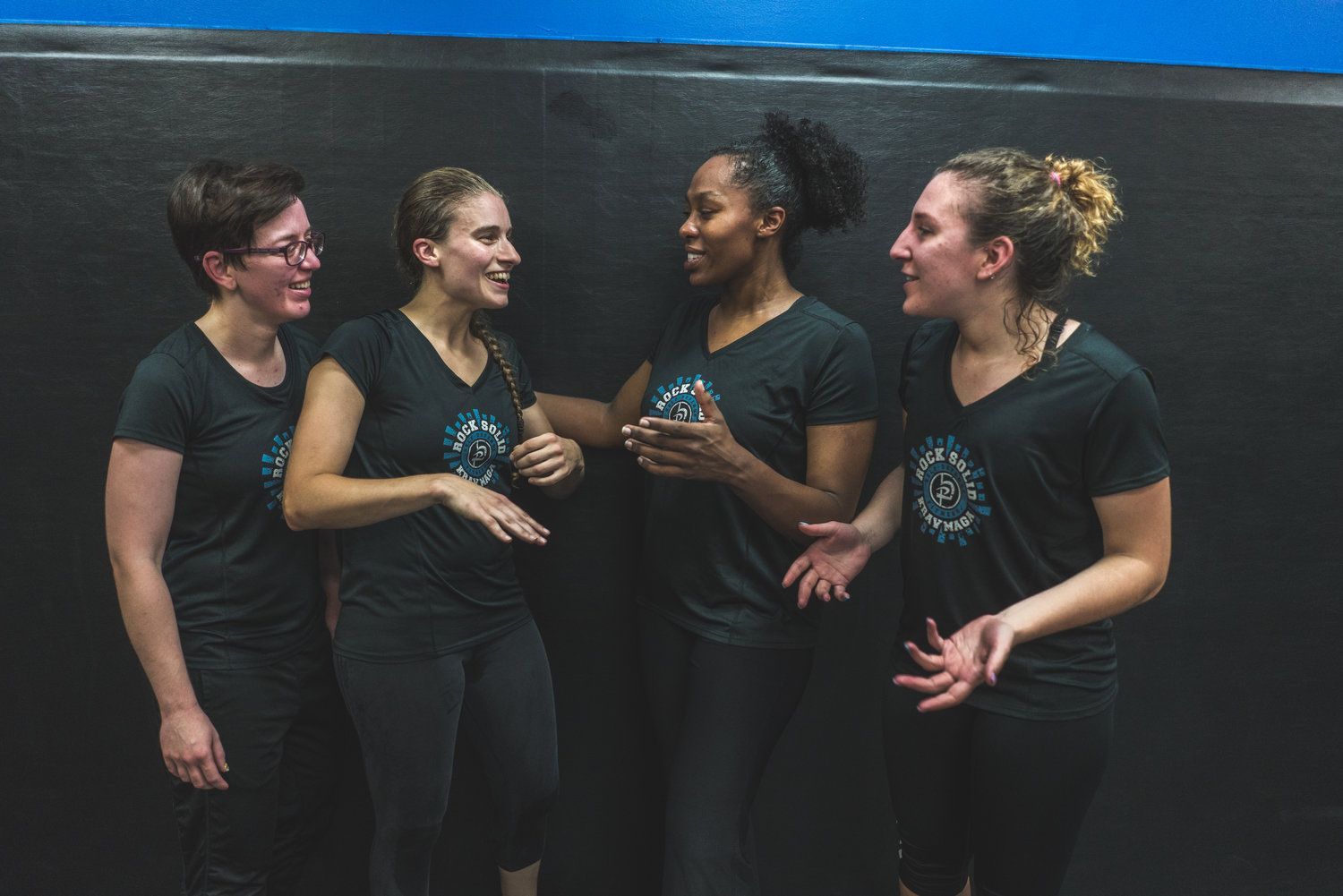 A group of women are standing next to each other and talking.