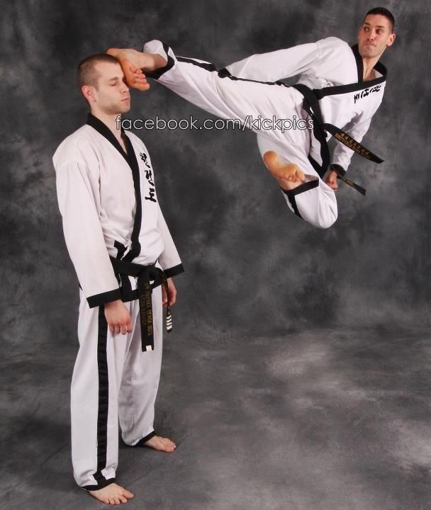 A group of children are practicing martial arts in a gym.