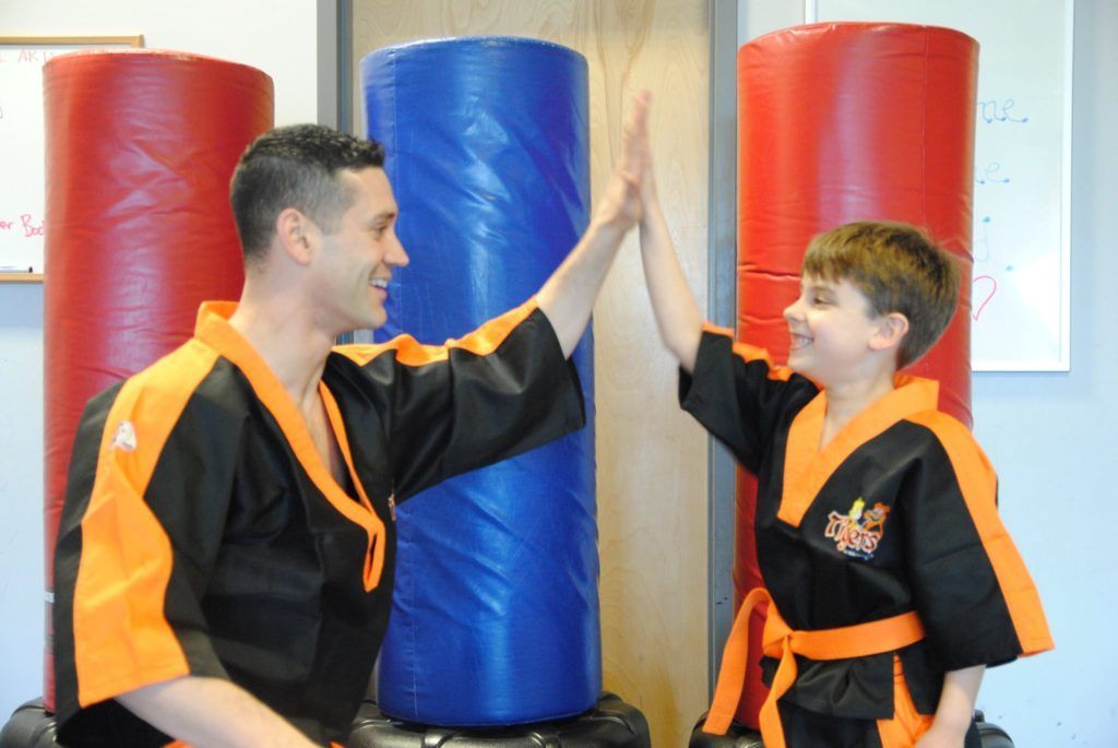 A man and a boy are giving each other a high five