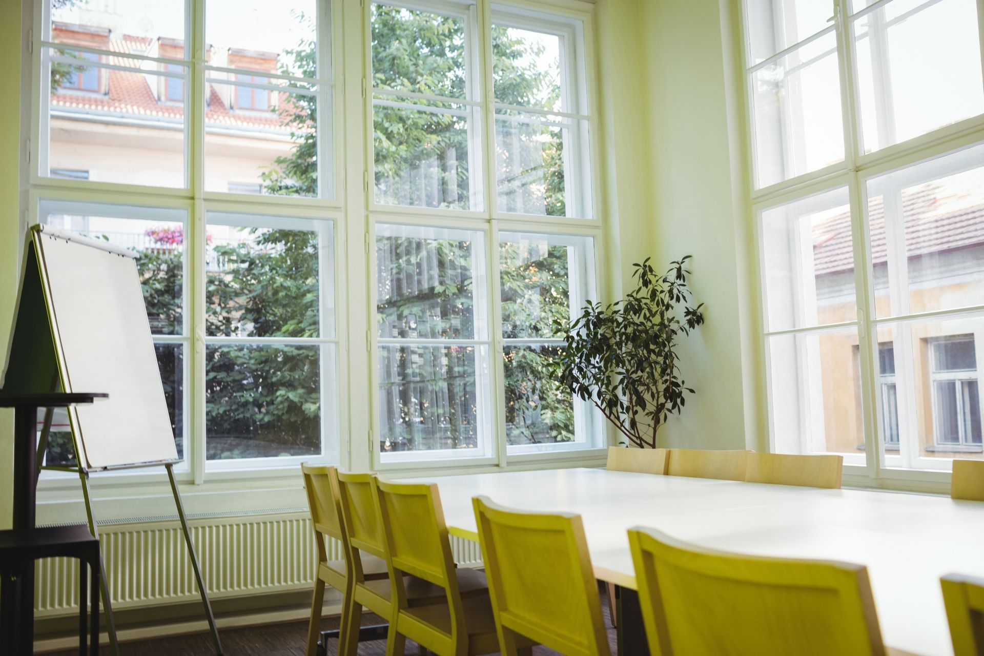 A conference room with a long table and yellow chairs.