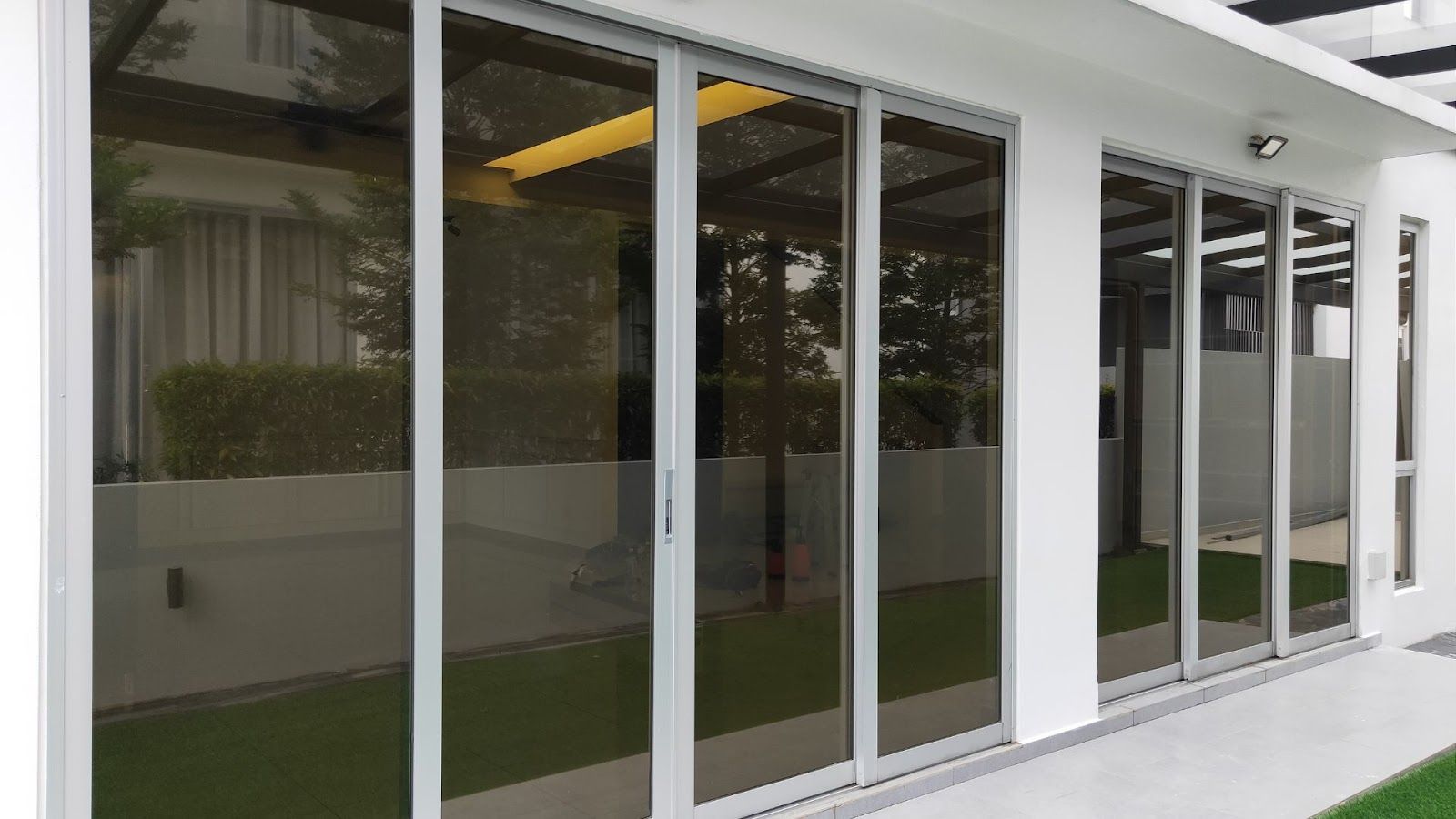 A white building with a lot of windows and sliding glass doors.