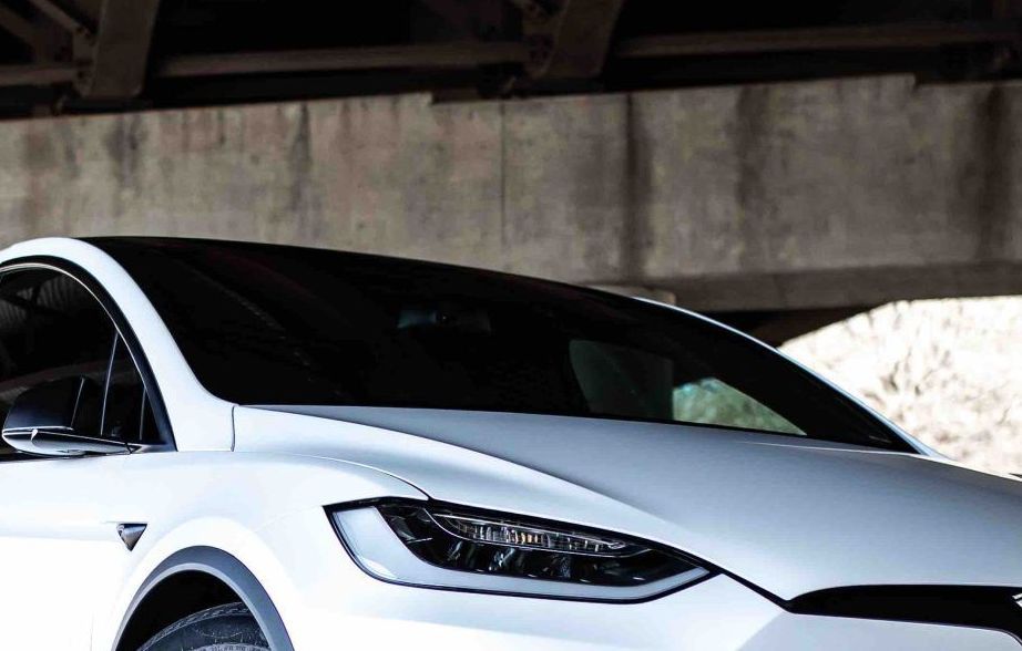 A white tesla model y with a blue roof on a white background.