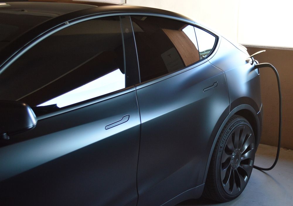 A tesla model y is charging in a garage