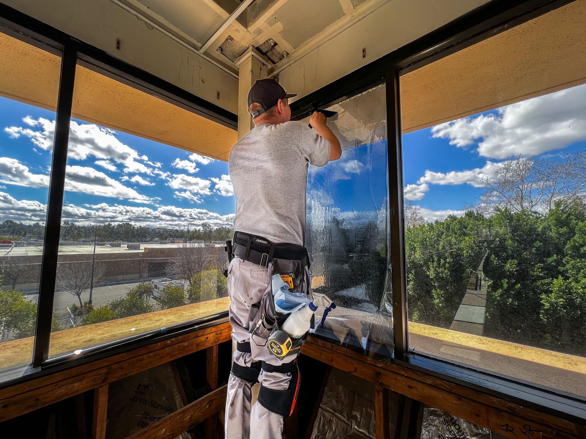 A man is working on a window in a building.