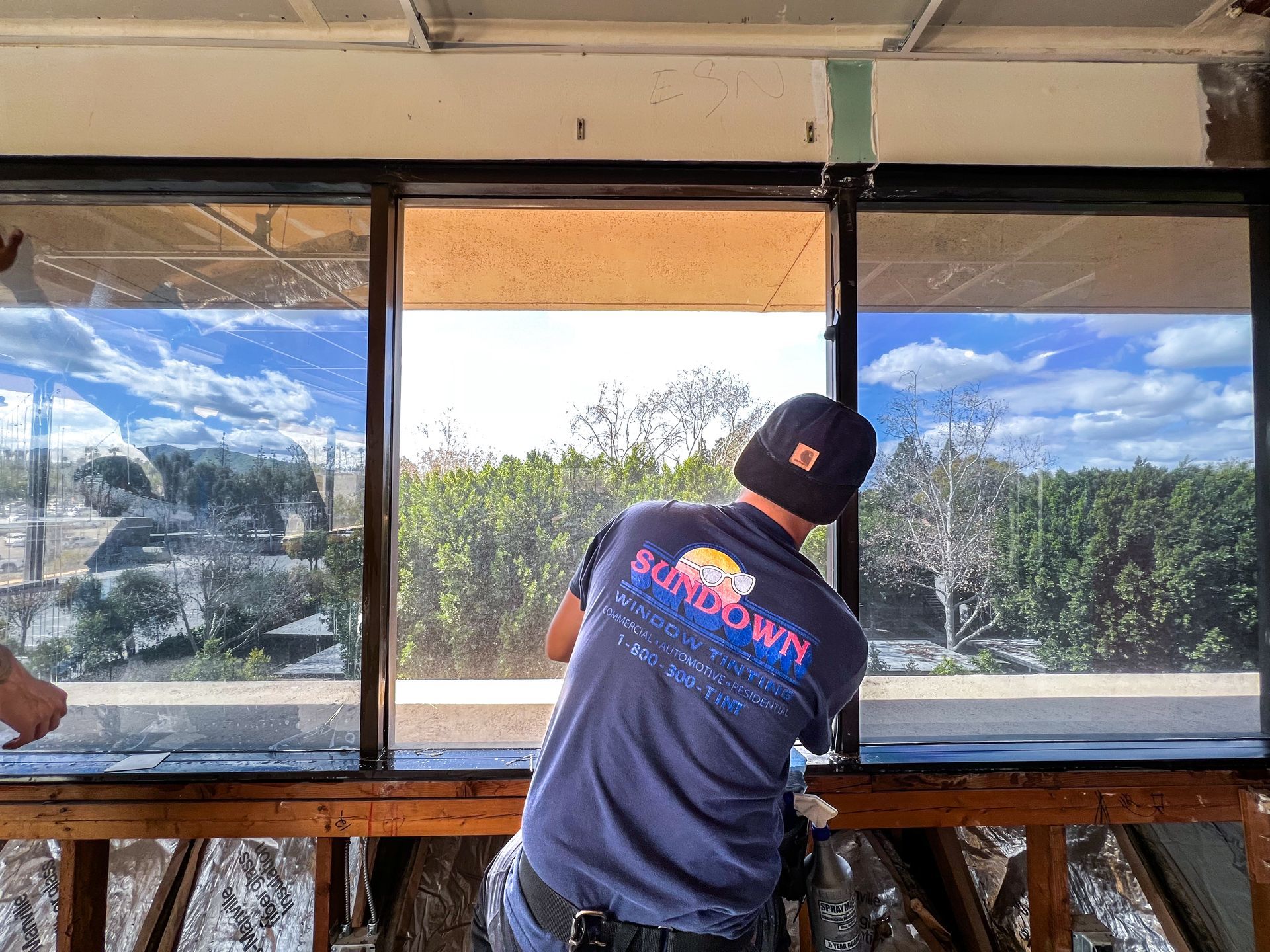 A person is applying tinted glass to a window.