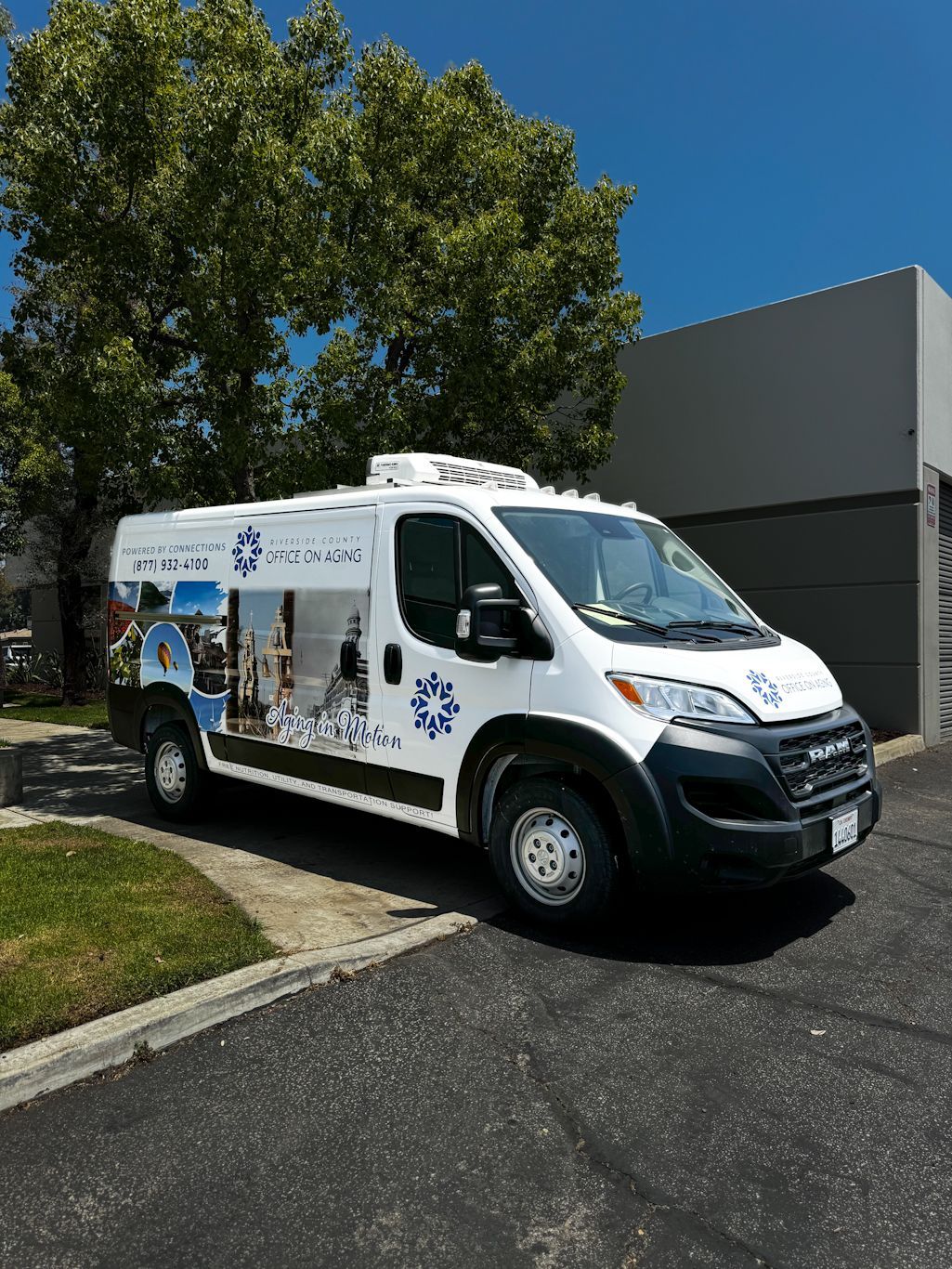 A white van is parked in a driveway in front of a building.