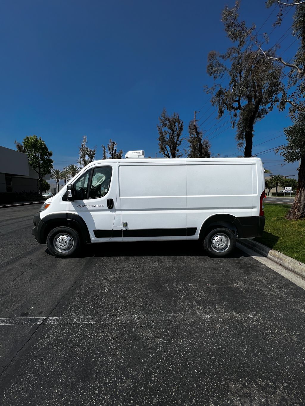 A white van is parked on the side of the road.