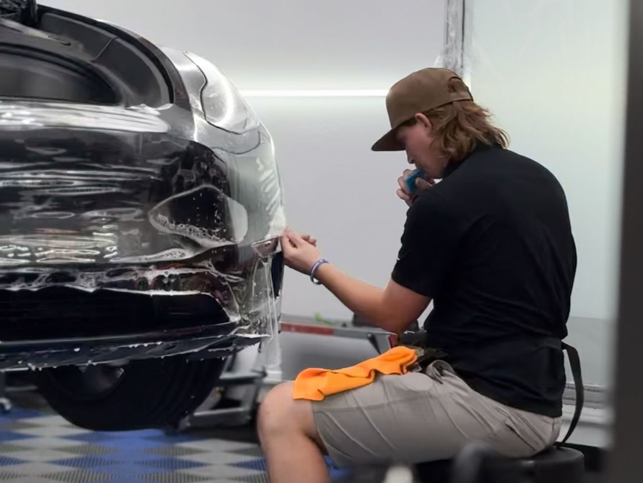 A man is wrapping a car with a towel