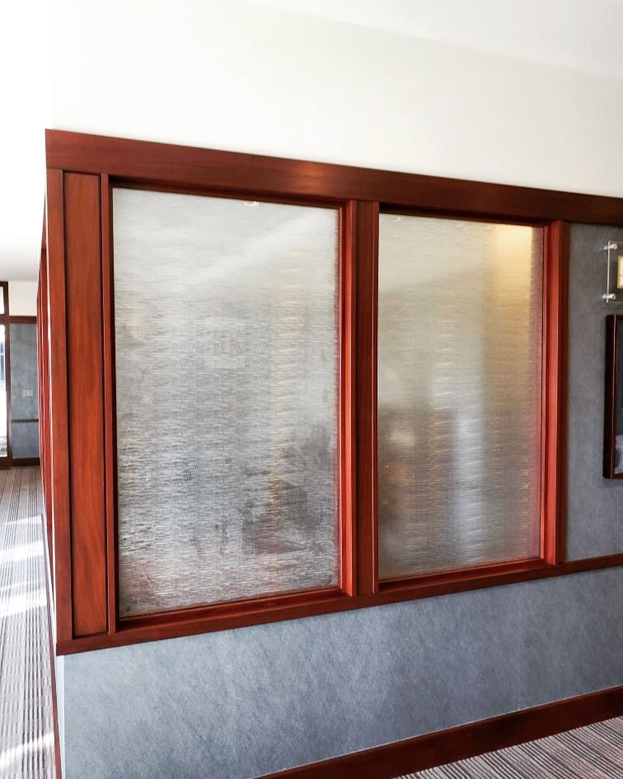 A hallway with two windows and a picture on the wall