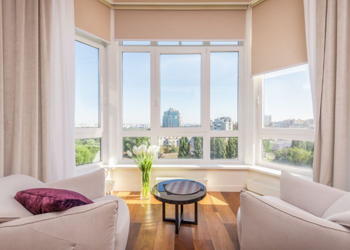 A living room with two chairs and a table in front of a large window.