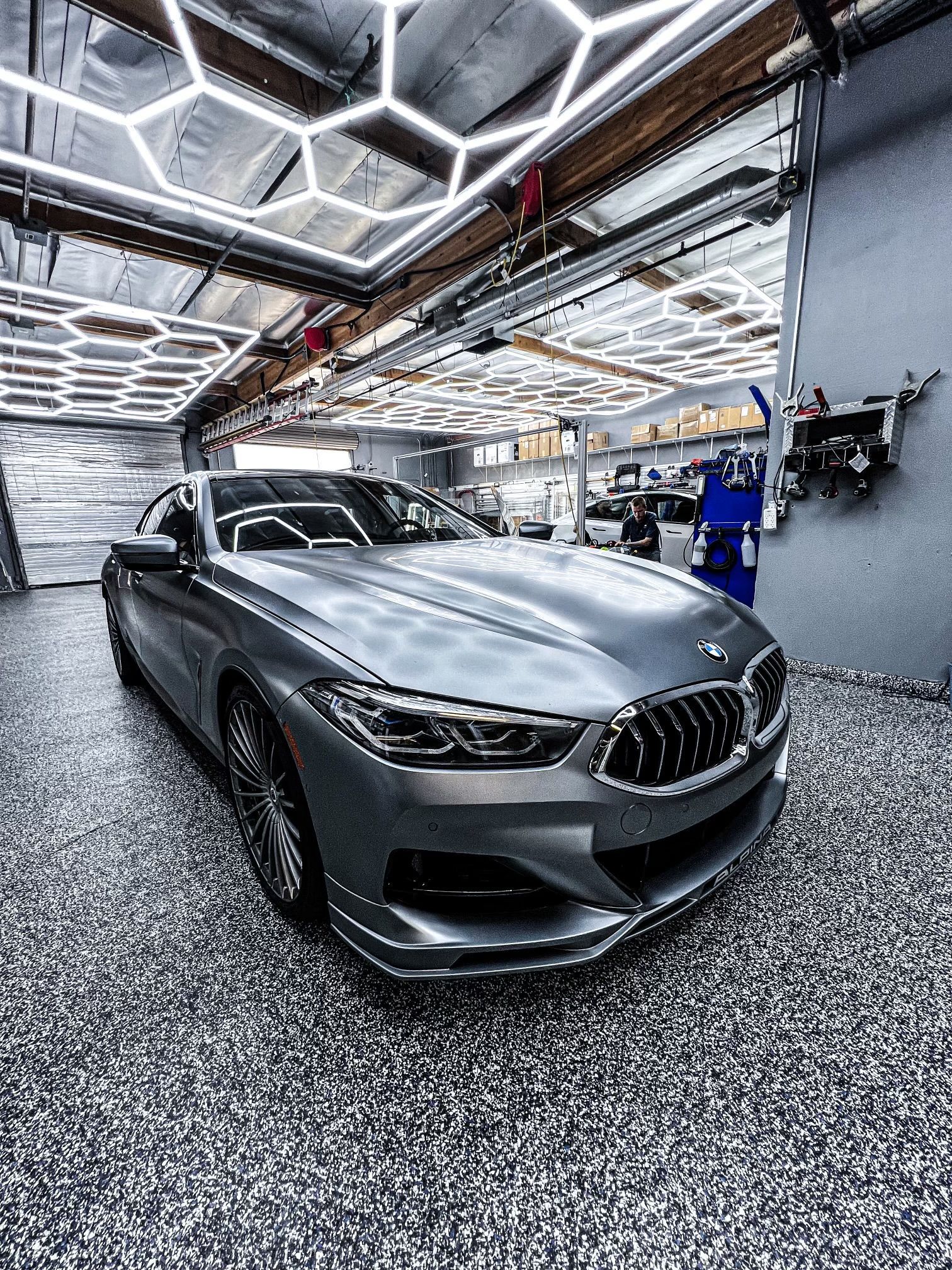 A bmw 8 series is parked in a garage.