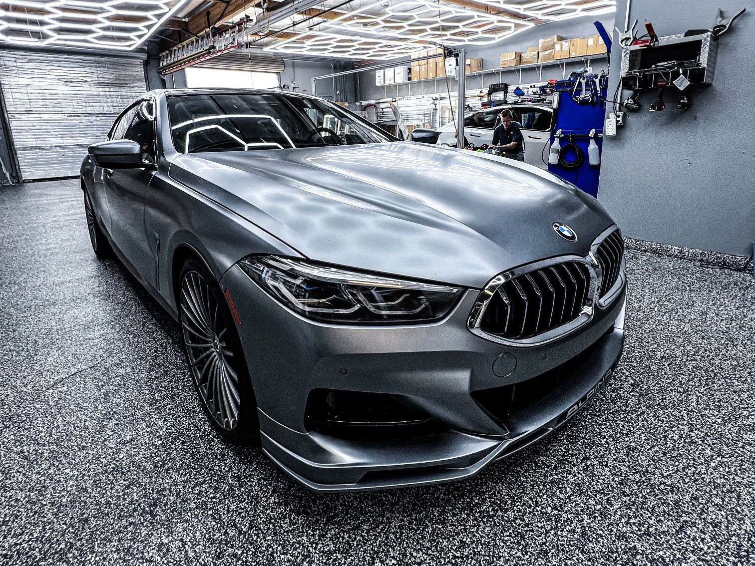 A bmw 8 series is parked in a garage.