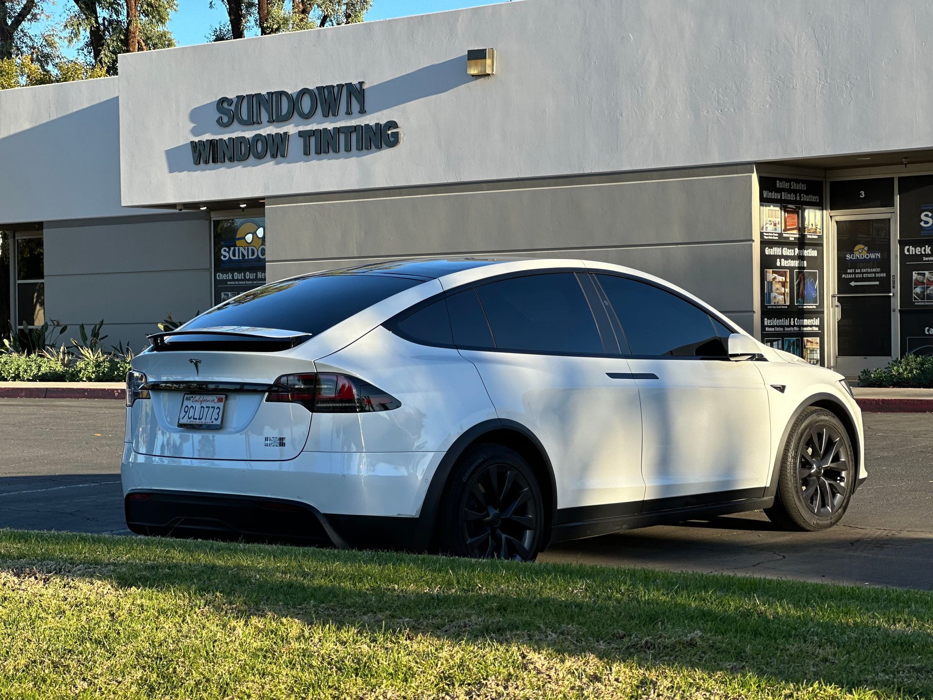A white tesla model y with blue windows on a white background.