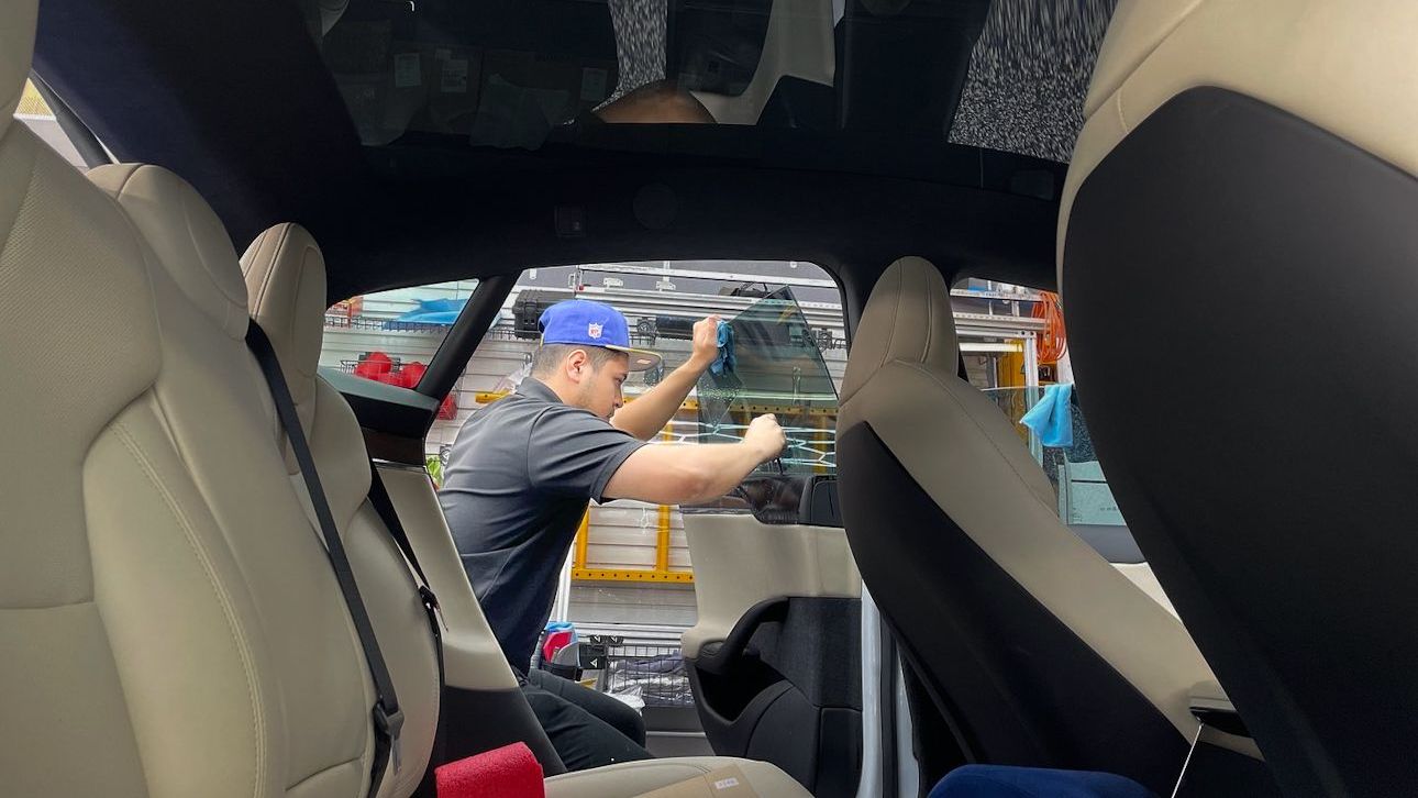 A man in a blue hat is working on a car